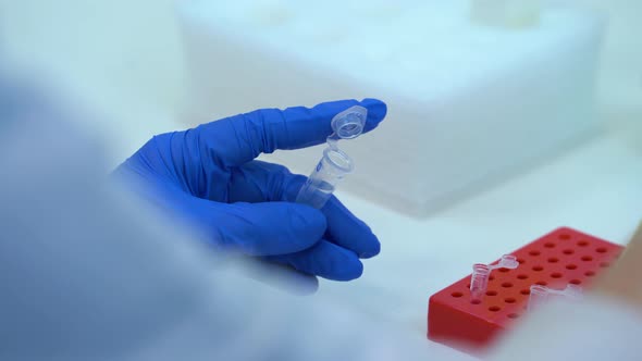 Test tubes in lab.  A scientist hand takes a liquid solution from a test tube.