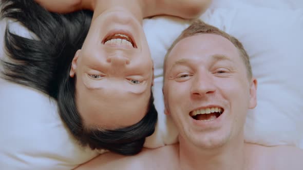 Close Up Smiling Faces Pair on the Bed