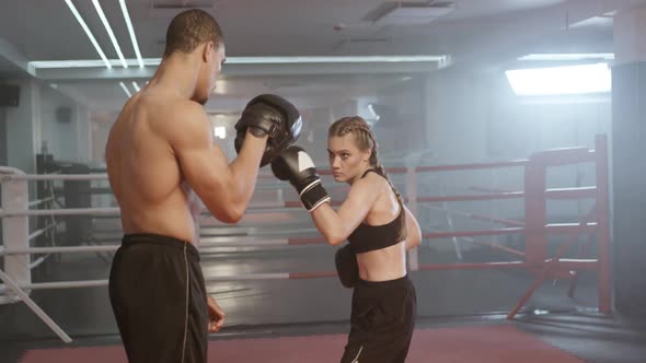 Cinematic Shoot of Boxing in the Ring Woman Fighter Trains Punches and Defence Punching Focus Mitts