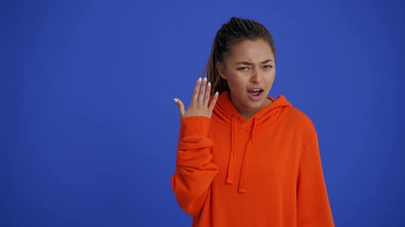 Handsome African woman with braid hairstyle showing don't hear gesture