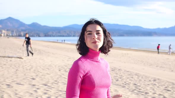 Young Woman on the Beach Against the Background of the Sea