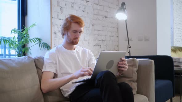 Casual Designer Working with Laptop in His Lap, Beard