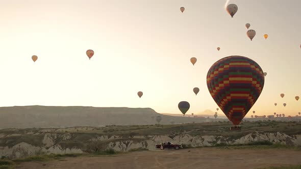 Young beautiful woman walking in front of Cappadocia landscape at sunset. Turkey.