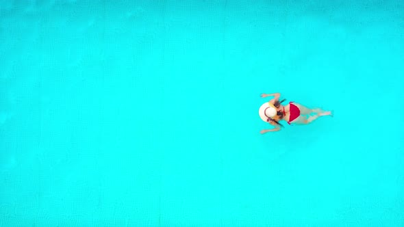 View From the Top As a Woman in Red Swimsuit Swims in the Pool