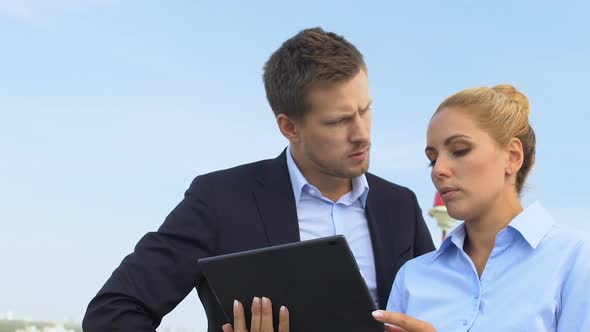 Business Partners Looking at Tablet, Discussing Important Project Outdoors