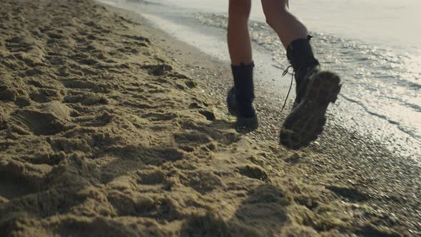Fashionable Woman Legs in Boots Running on Beach