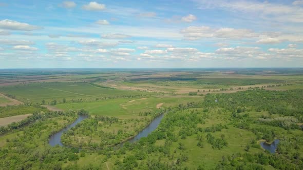 Flight Over Green Meadow, Forest and River in Spring