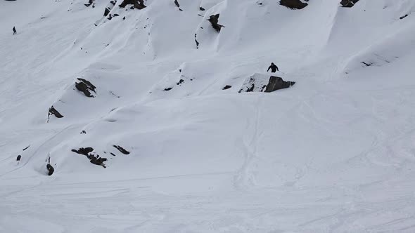 A man skiing and jumping on a snow covered mountain