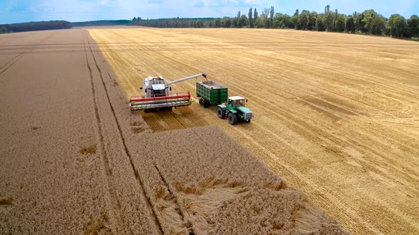Aerial shot of combine loading off corn grains into tractor trailer