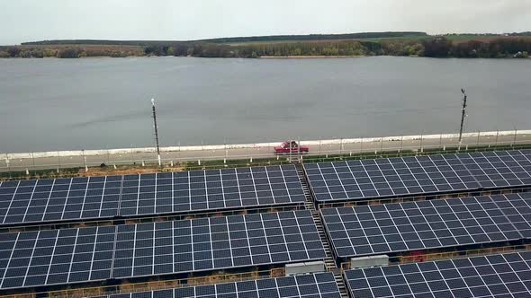 Solar panels near the river. Power station. Blue solar panels. Alternative source of electricity.