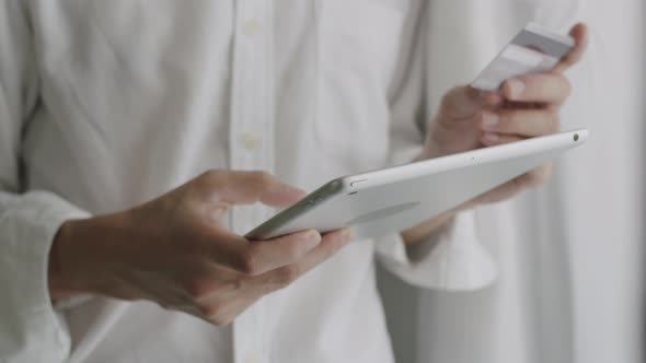 Close-up businessman using tablet purchase online shopping and use a credit card payment.