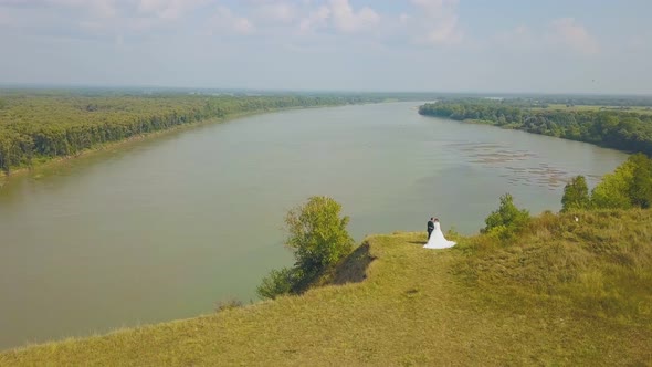 Newly Wedded Couple on Steep Riverbank Bird Eye View