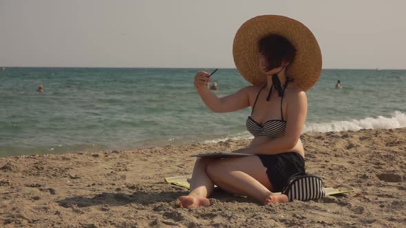 Girl Is Drawing Watercolor Sketch on the Seashore