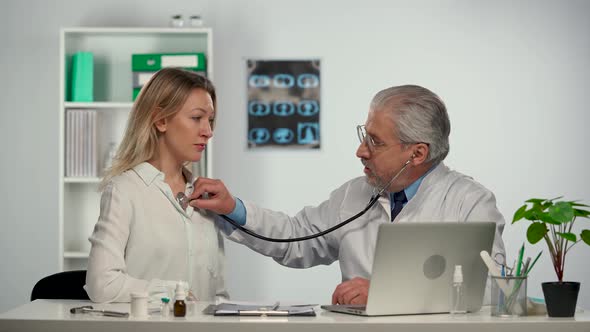 Family Medicine Doctor Examines a Woman Patient with a Stethoscope