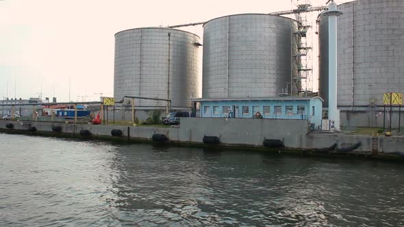 View from sea at industrial storehouses with annex buildings at maritime port