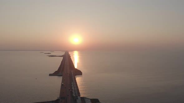 View From Above on a Long Road in the Middle of the Water Against the Sunset or Sunrise