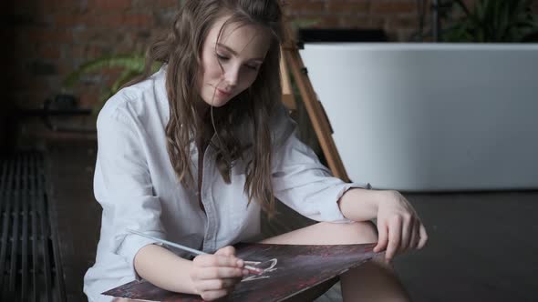 Portrait of an Attractive Girl Painter Working in a Relaxed Atmosphere. Artist Paints a Picture in a