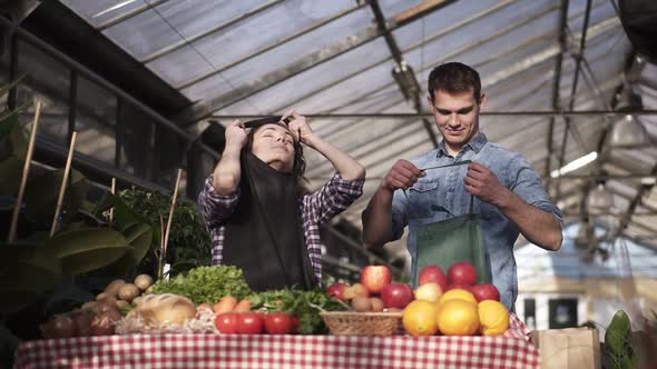 Portrait of Beautiful Caucasian Farmers Man and Woman Putting Aprons and Gloves Selling Organic Food