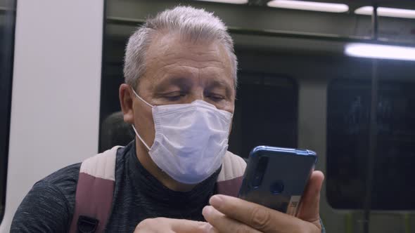 Senior Commuter Using Mobile in Subway