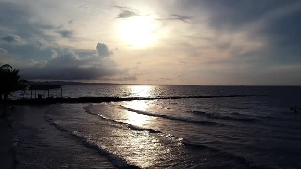 Beach and beautiful sunset at the ocean. Calm waves washing on sand