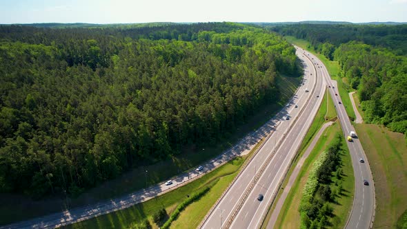 Vehicles Running Through An Expressway And Highway Passing By Green Forest In Gdynia, Poland. - aeri