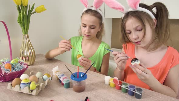 Two Sisters Decorate Easter Eggs with Colors and Help Each Other