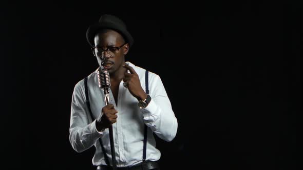 Male African American Musician Singing in a Recording Studio. Black Background