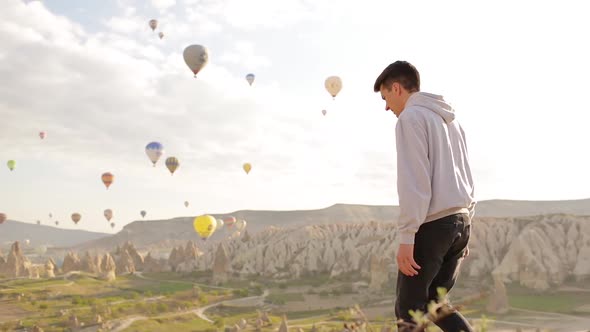 Young Man Sits And Looking To The Air Balloons.