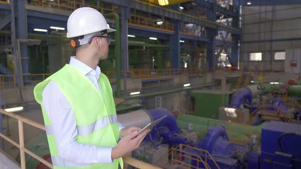 The fabricator works with the tablet in the factory.