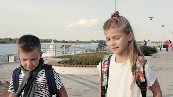 Boy and Girl with Backpacks Walking and Talking. Primary Education, Friendship, Childhood