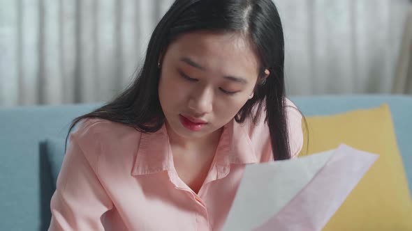 Close Up Of Asian Woman Looking At The Bill And Recording The Expenses In Notebook