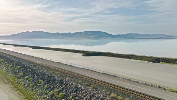 AERIAL - Mountain range and railroad tracks, Great Salt Lake, Utah, truck right