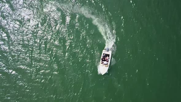 Aerial Top Down Tracking shot of motor boat speeding away in a circle