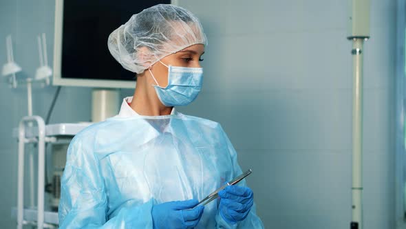 Nurse in the Operating Room Assists the Doctor.