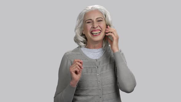 Old Retired Lady Talking on Phone and Laughing Heartily Out Loud