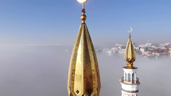 The Golden Crescent moon on a background of blue sky and fog.