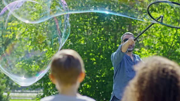 Kids Watching Soap Bubble Show in Park alt