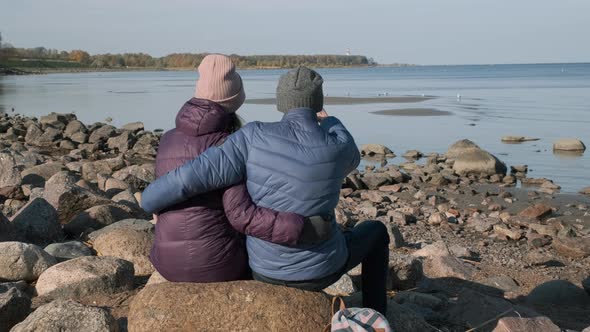 Couple Hugging on a Stone Coast in Autumn Day