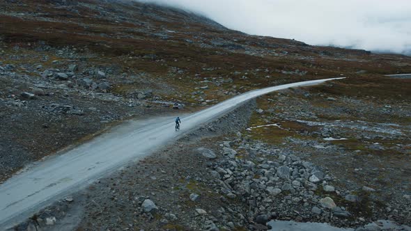 Following Flying Shot of Cyclist Exploring on Road