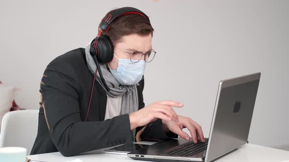 Young Businessman Working at Home with Face Mask