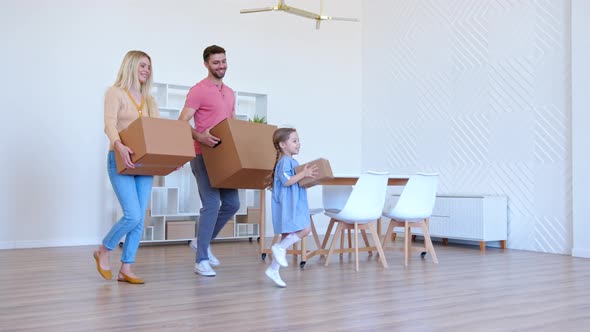 Delighted family parents with kid walk into new apartment room