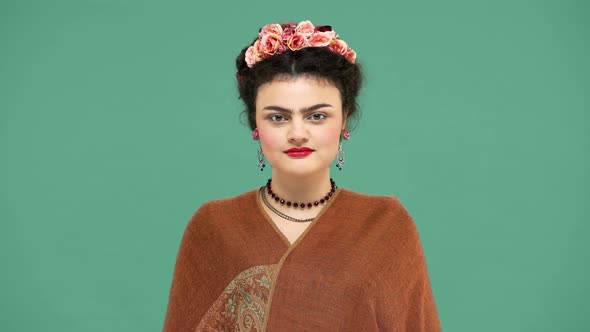 Fashion Portrait of Woman with Flowers in Hair As Frida Kahlo Posing on Camera with Playful Look