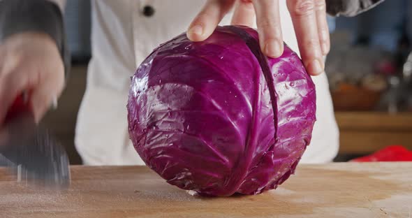 Slow motion close up of a chef knife slicing a Red cabbage