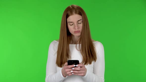 Portrait of Pretty Young Woman Is Texting on Her Phone.