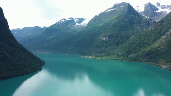 Wide panoramic view over stunning Oldedalen valley with glaciers on mountaintops and emerald green f