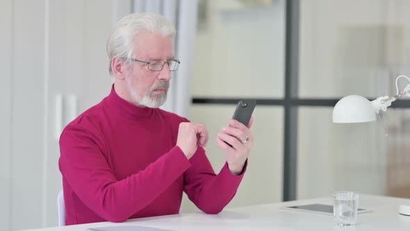 Old Man Using Smartphone at Work