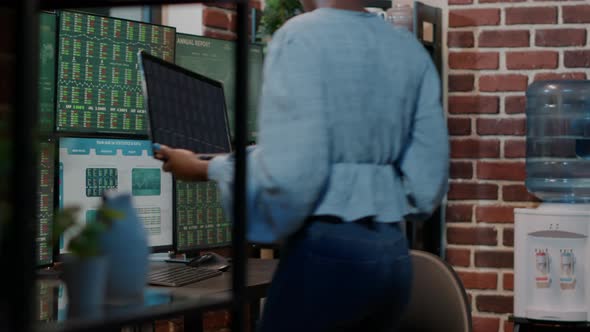 Bank Employee Analyzing Forex Exchange Sales on Laptop