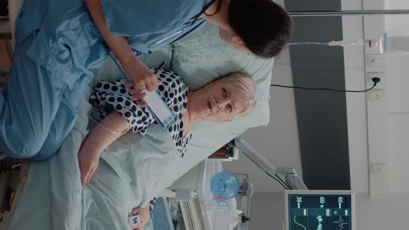 Vertical Video Nurse Giving Assistance to Senior Patient with Disease in Bed