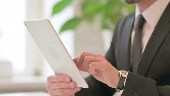 Close Up of Hands of Middle Aged Businessman Working on Tablet