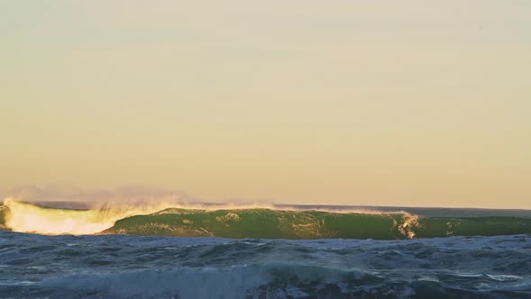 Ocean Waves Breaking Background in Dramatic Orange Sunset Light, Sea Crashing Below Horizon from Low